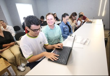 Pais e responsáveis acompanham entrega de notebooks para estudantes com deficiência visual, em Goiânia